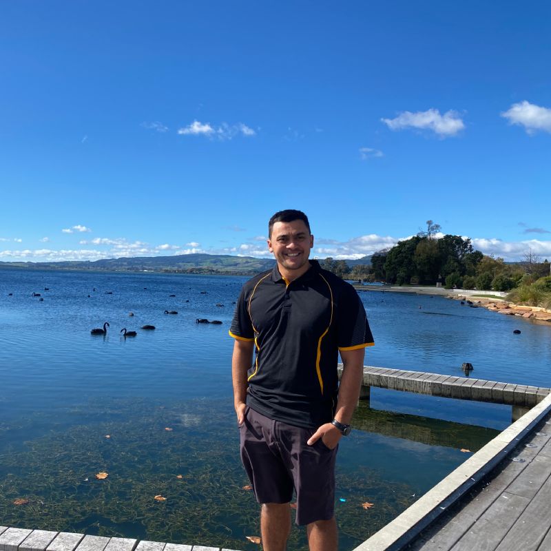 Stanley Ulrich standing in front of Lake Rotorua on a wharf.