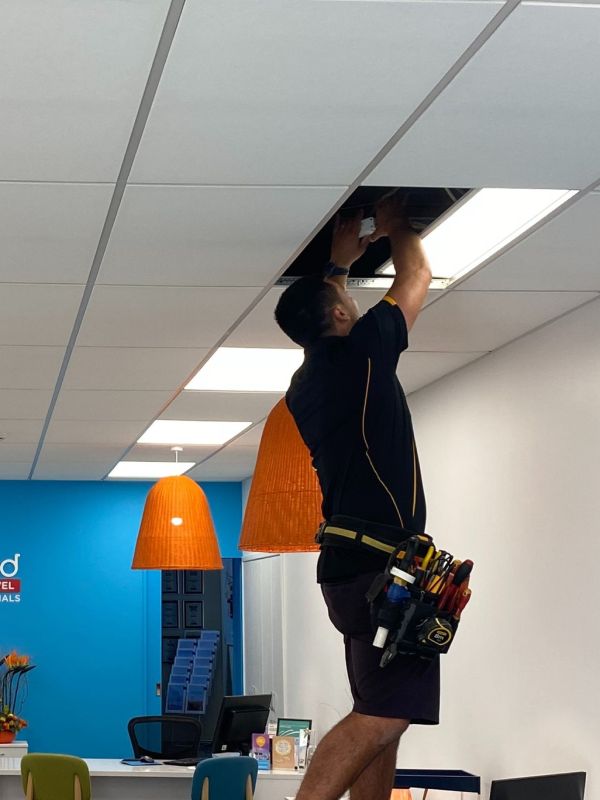 Stanley Ulrich fitting moving some wires in the ceiling of a commercial business.